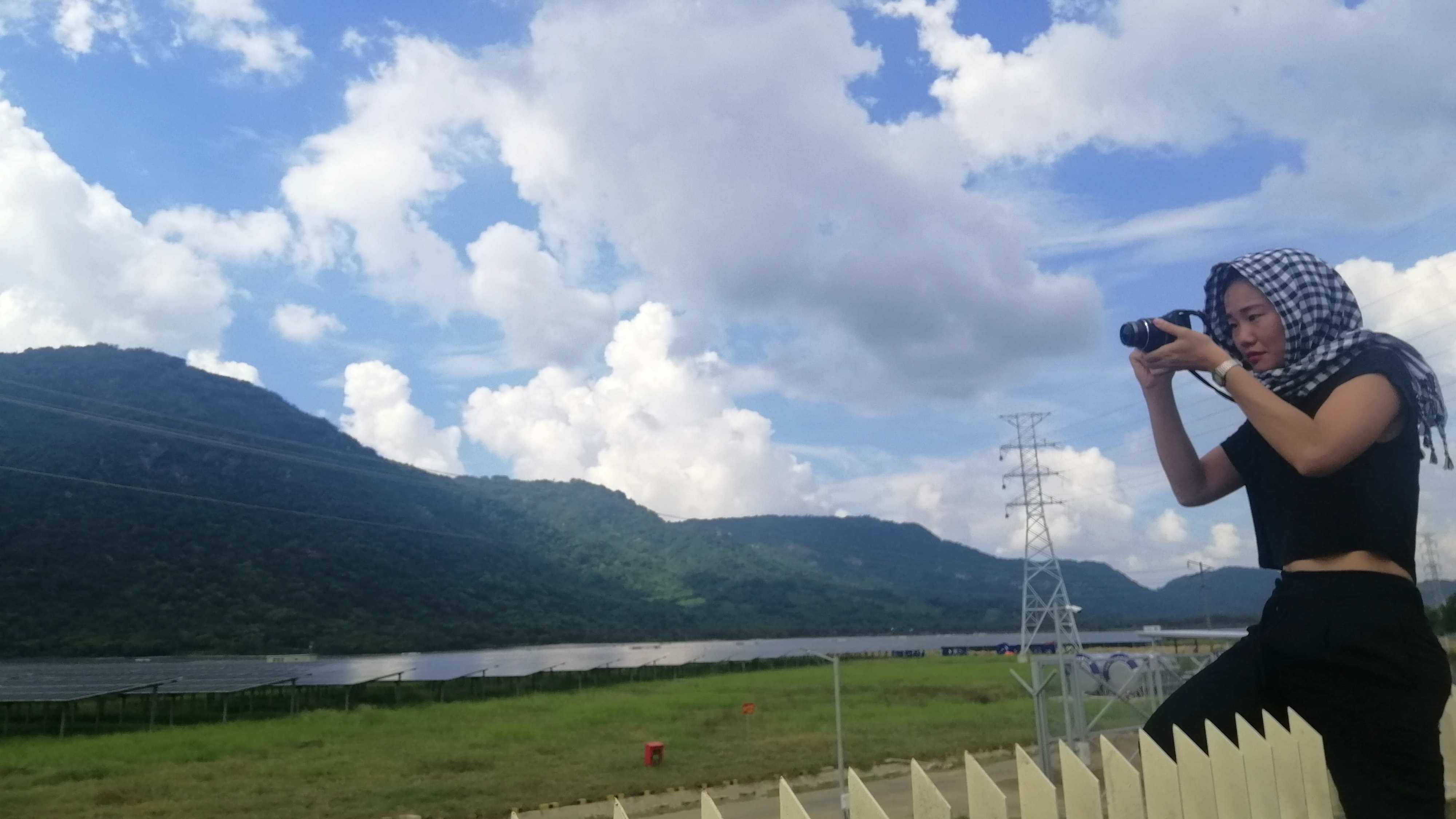 Sen Nguyễn ngồi trên hàng rào chụp ảnh cánh đồng pin mặt trời tại An Giang năm 2020 | Nguồn Sen Nguyễn