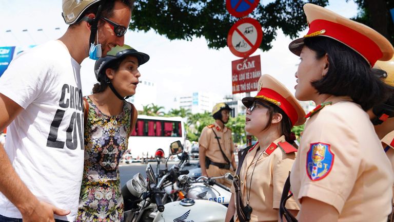 The Spanish couple, after being reminded of the law, smiled and asked to take a commemorative photo with the traffic police officer. | Source: Thanh Niên